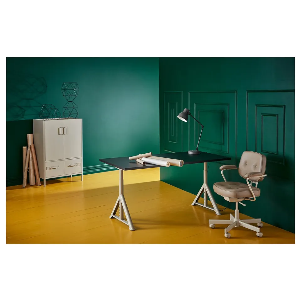Modern green office setup with IDÅSEN desk, white legs, beige chair, lamp, and storage unit with decorative items.