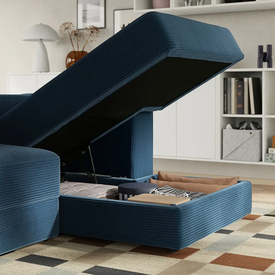 Blue modular sofa with storage. Seat lifted, showing internal storage space. Soft fabric, pocket springs, easy movement.