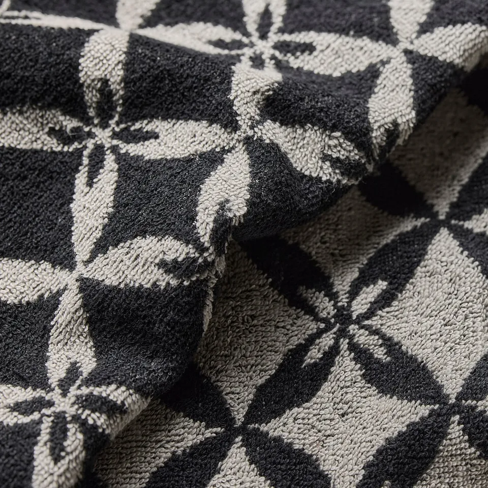 Close-up of black and white patterned rug. Intricate designs and soft, textured cotton material.