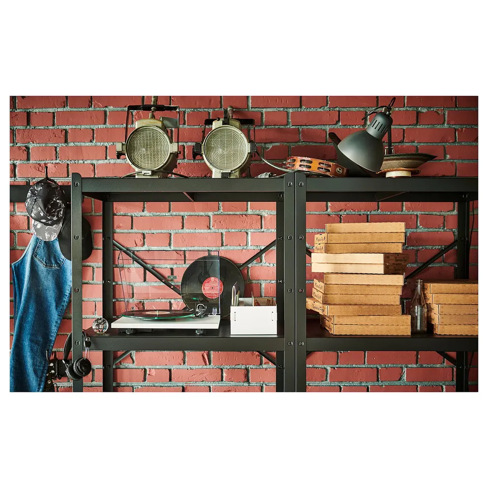 Brick wall shelf setup with turntable, lamps, and books. Metal frame, vintage style.