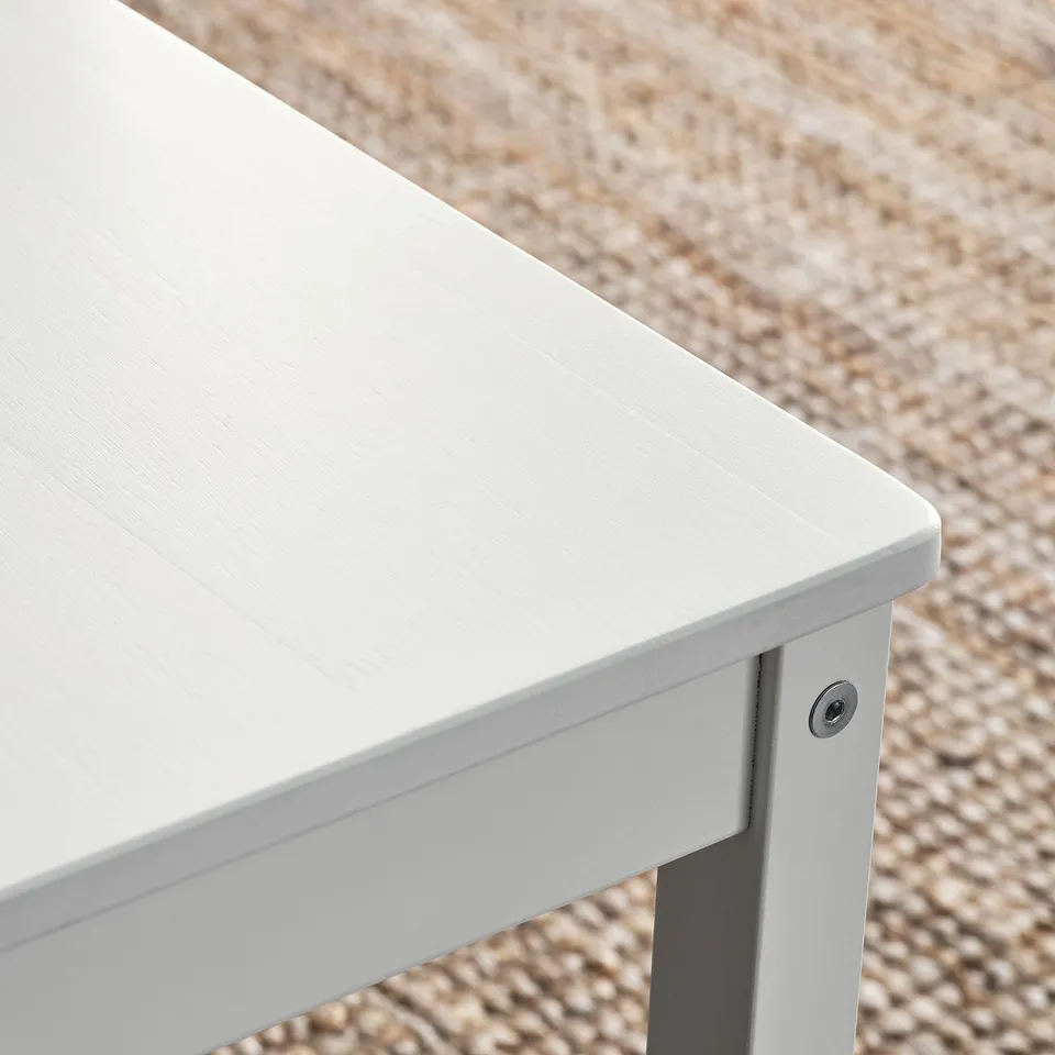 Close-up of white table leg, showing smooth finish and quality craftsmanship.