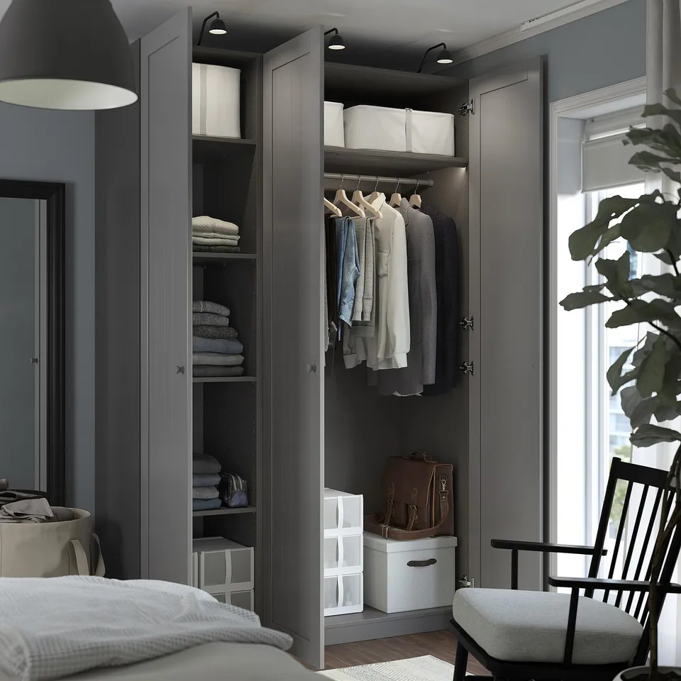 Open wardrobe with clothes, folded towels, boxes, and bags inside, demonstrating organisation and storage solutions.