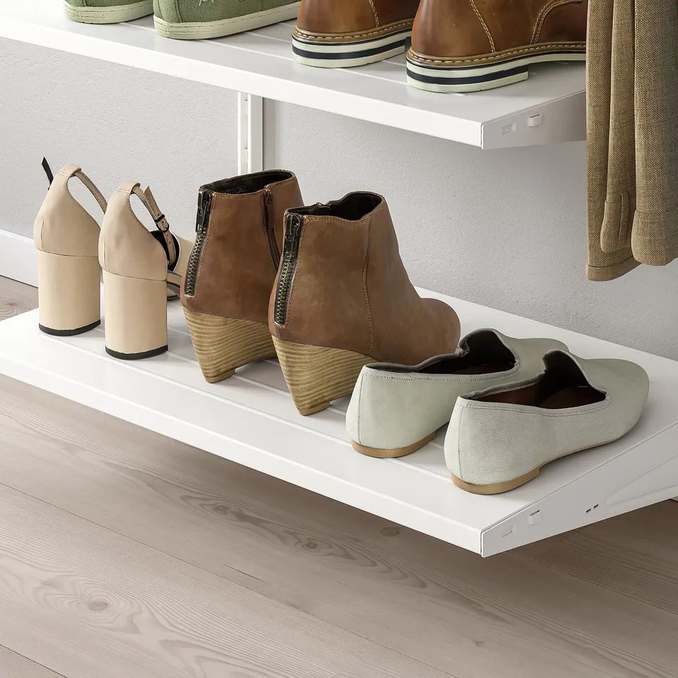 White shoe shelves mount on wall, holding various shoes. Organises footwear neatly, preventing clutter.