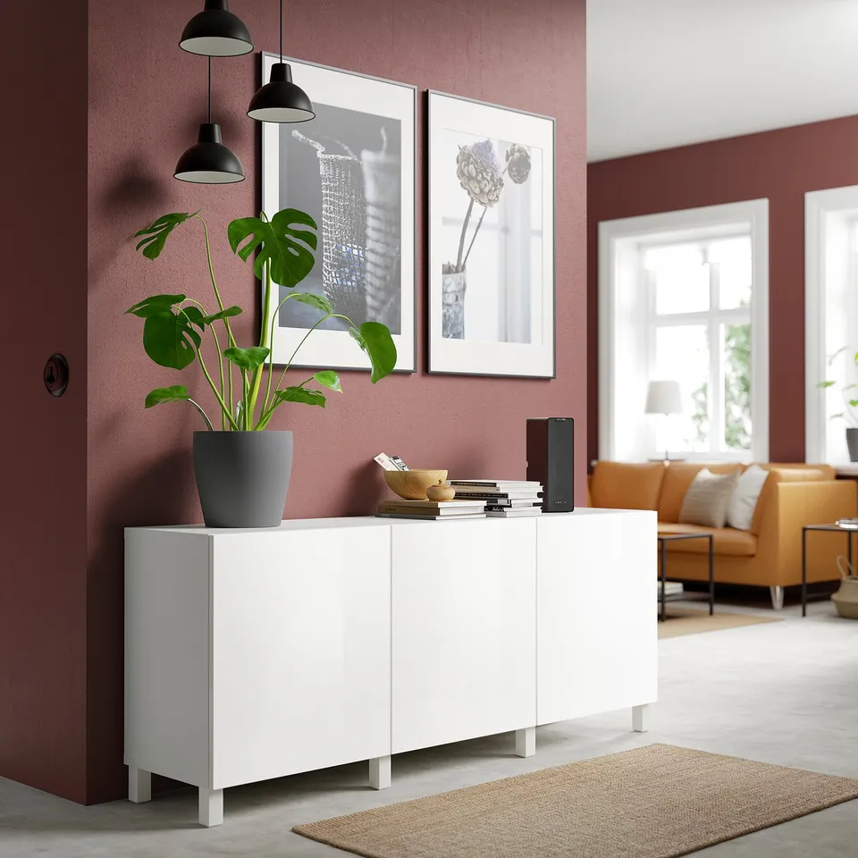 Modern living room with white SELSVIKEN cabinet, glossy, holding plants and decor.