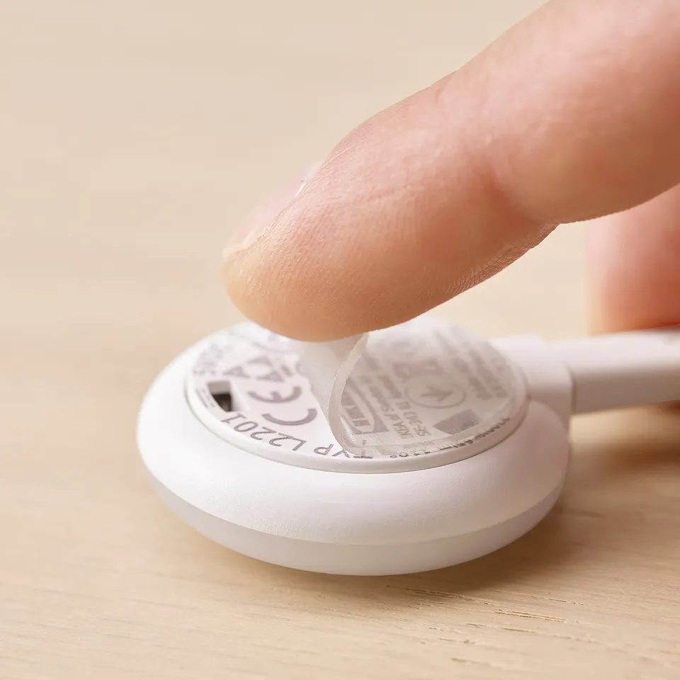 A hand peels a lamps sticky gel-pad for easy mounting, displaying KAPPLAKEs detachable design.