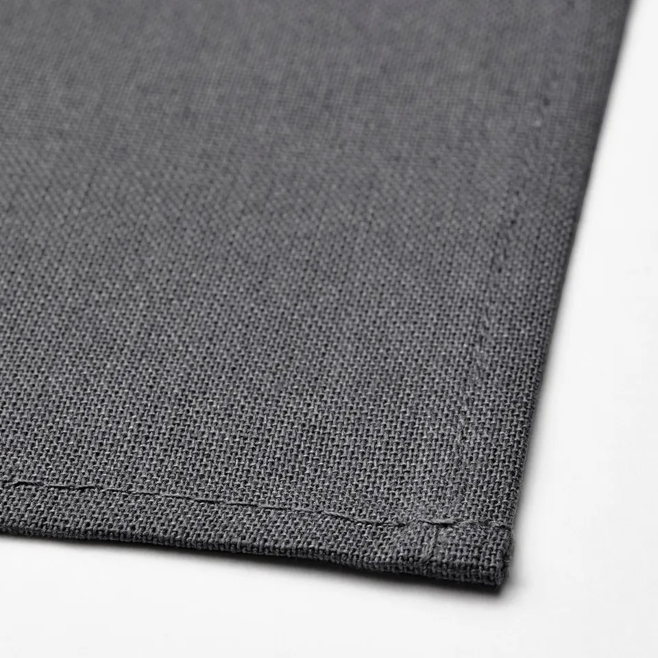 Dark grey cloth napkin, neatly folded, showcasing quality cotton texture and fine stitching.