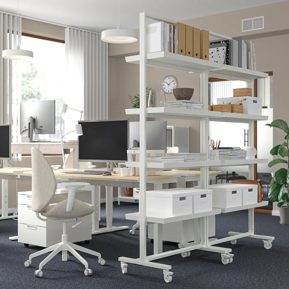 White shelving unit divides workspace, adjustable with locks.