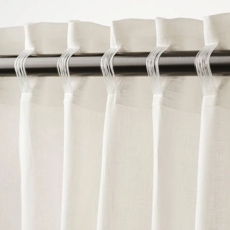 Pleated white curtains with easy attachment mechanism, offering privacy with daylight.
