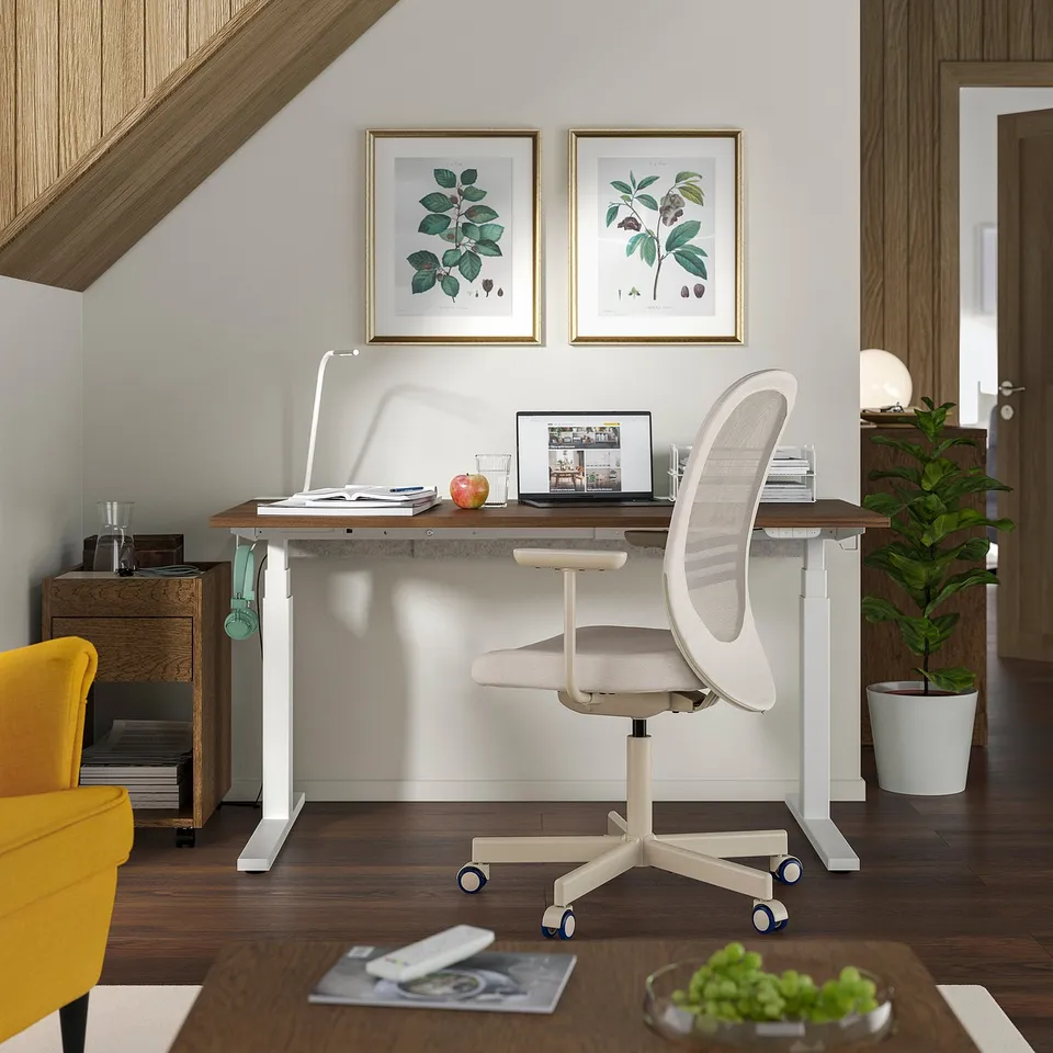 Home office setup with MITTZON standing desk, white chair, laptop, and decor.