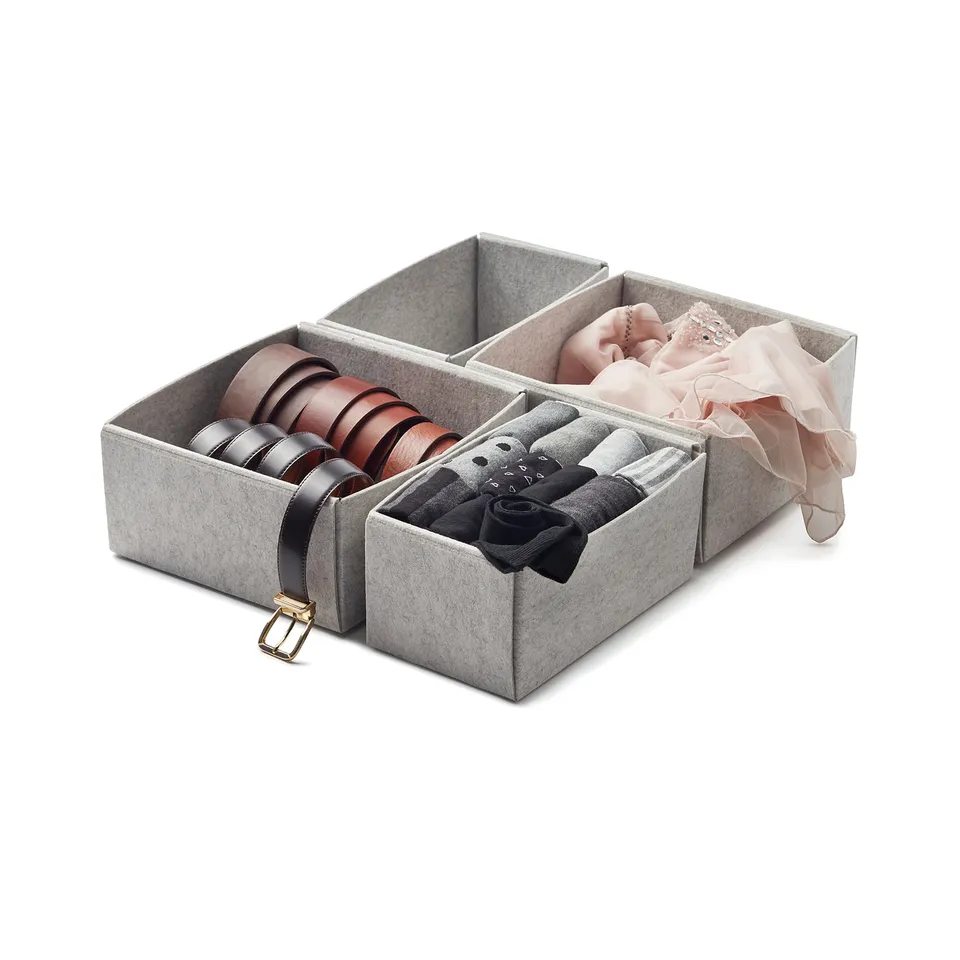 Grey felt boxes with brown and black belts, socks, and baby items; organised storage solution.