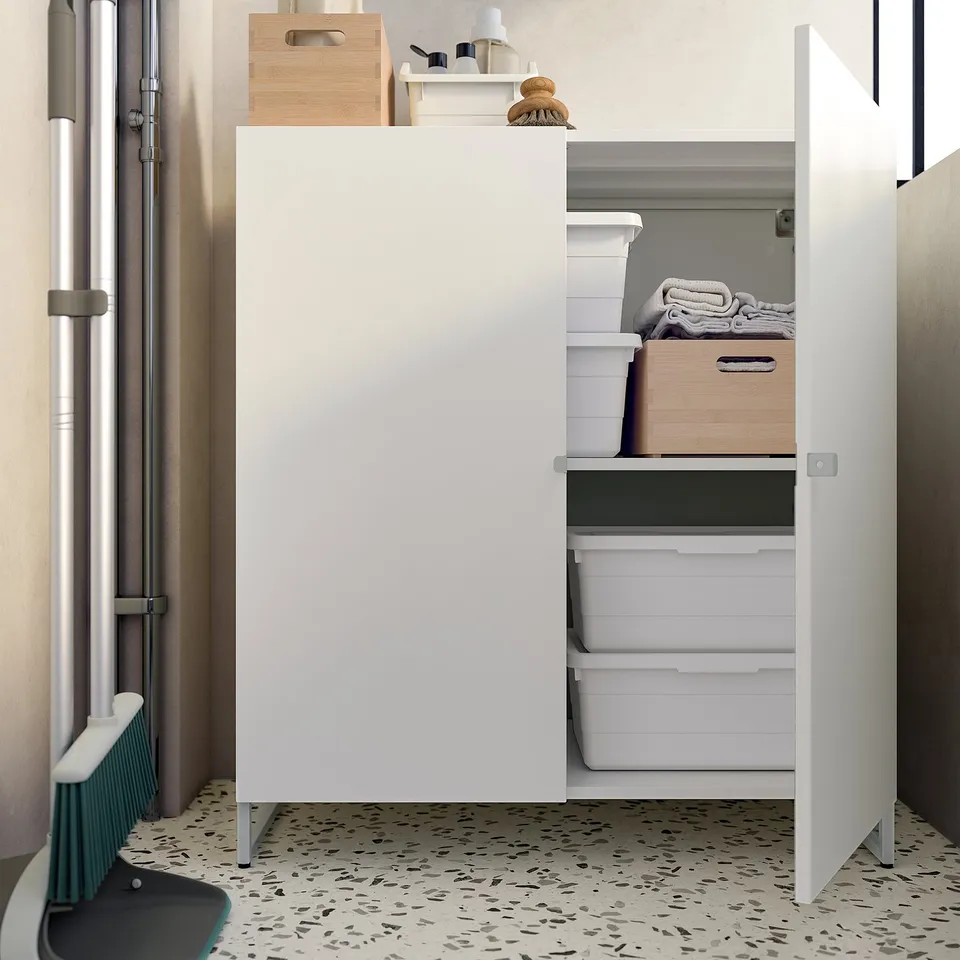 Clean white storage cabinet with folded towels inside.