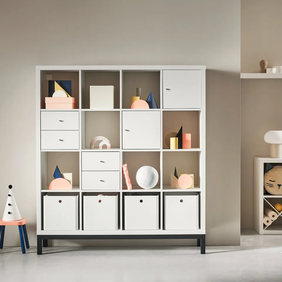 White KALLAX shelving unit with various compartments and colourful decorative items.