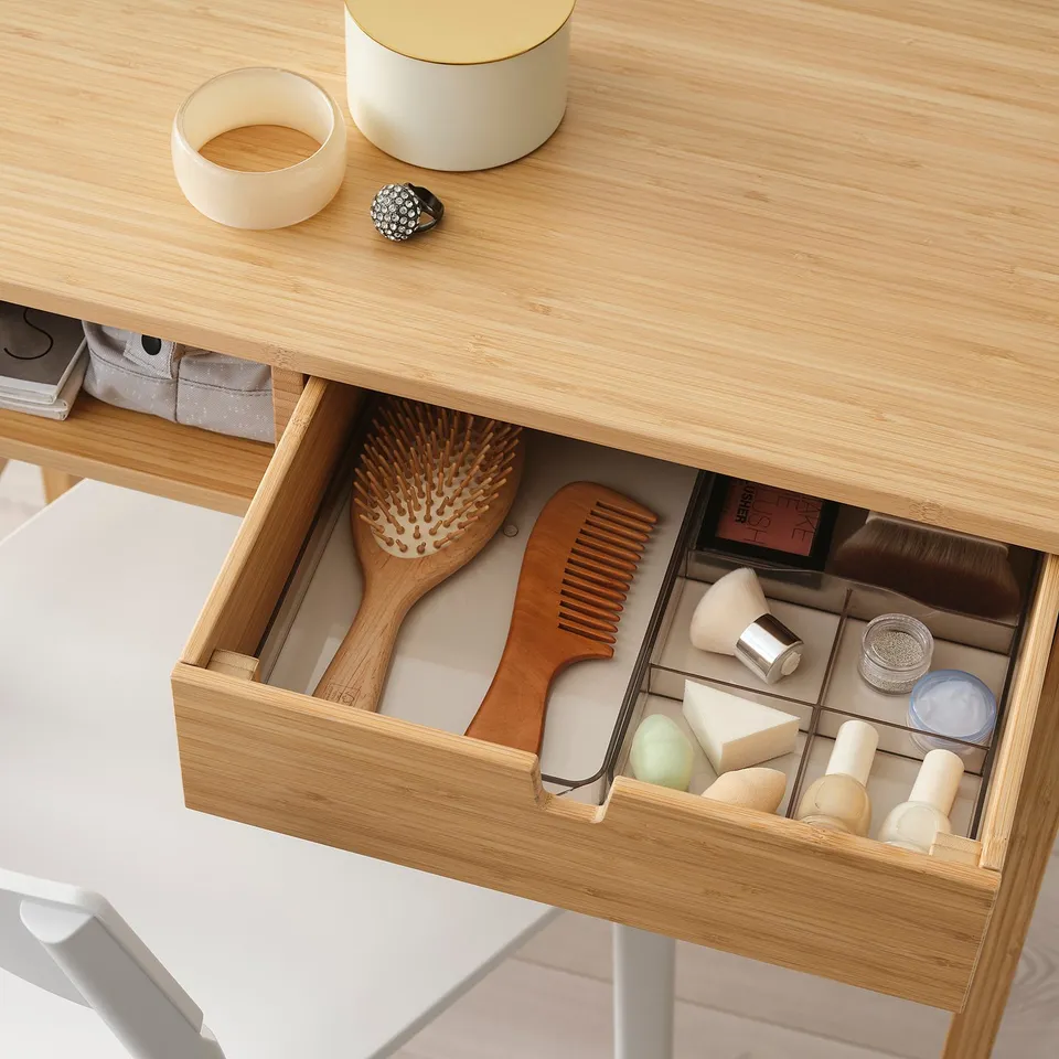 Bamboo dressing table with open drawer showing hairbrushes and makeup tools, accessible from both sides.