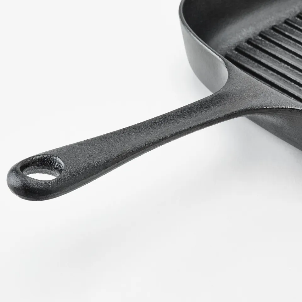 Close-up of a cast iron pan handle, showing its sturdy and well-constructed design.