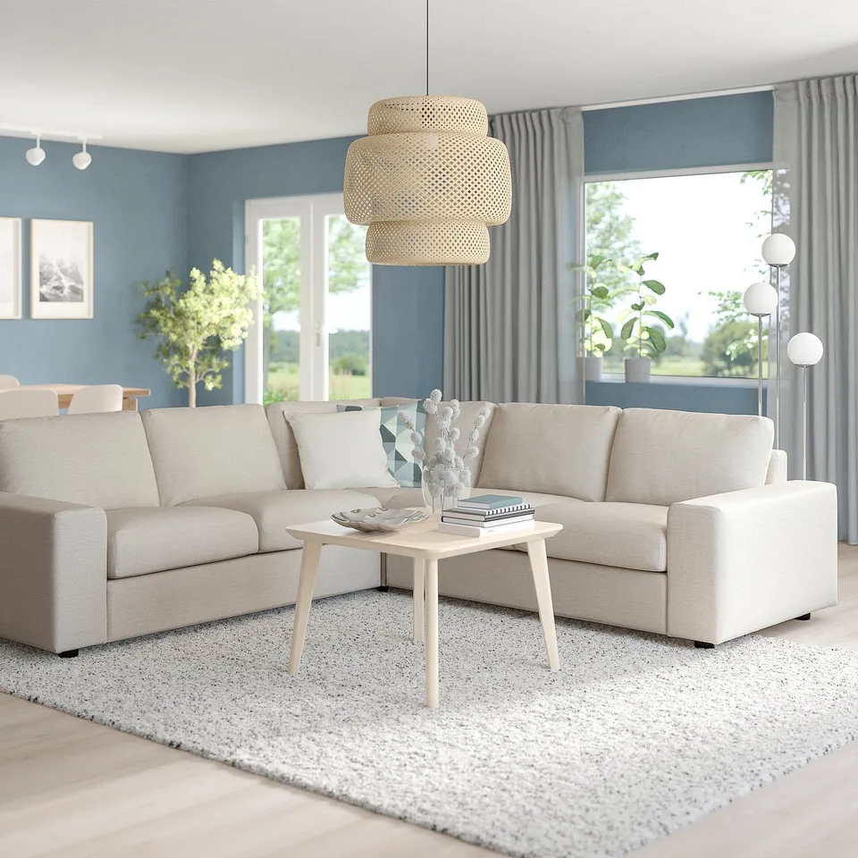 Cosy living room with grey VIMLE sofa, euros, pillow, blue wall, large window, tiered pendant lamp, coffee table, rug.
