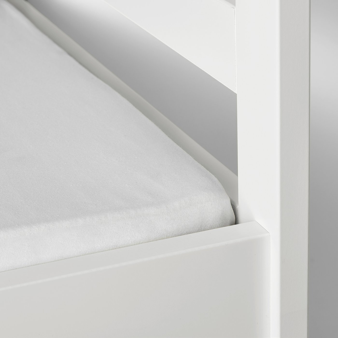 A fitted sheet with elastic keeping it taut on a mattress.