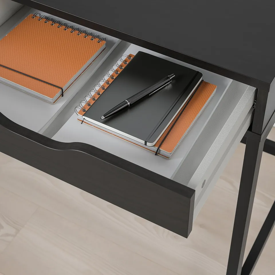 Open desk drawer reveals notebooks and pen, showcasing built-in storage solution.