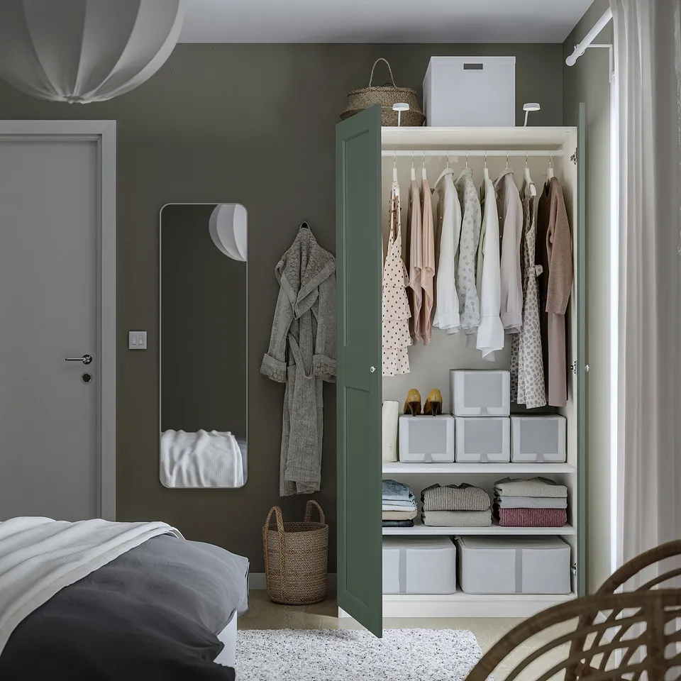 A modern wardrobe with tidy hangers and storage boxes for organised clothing and accessories, open to show interior.