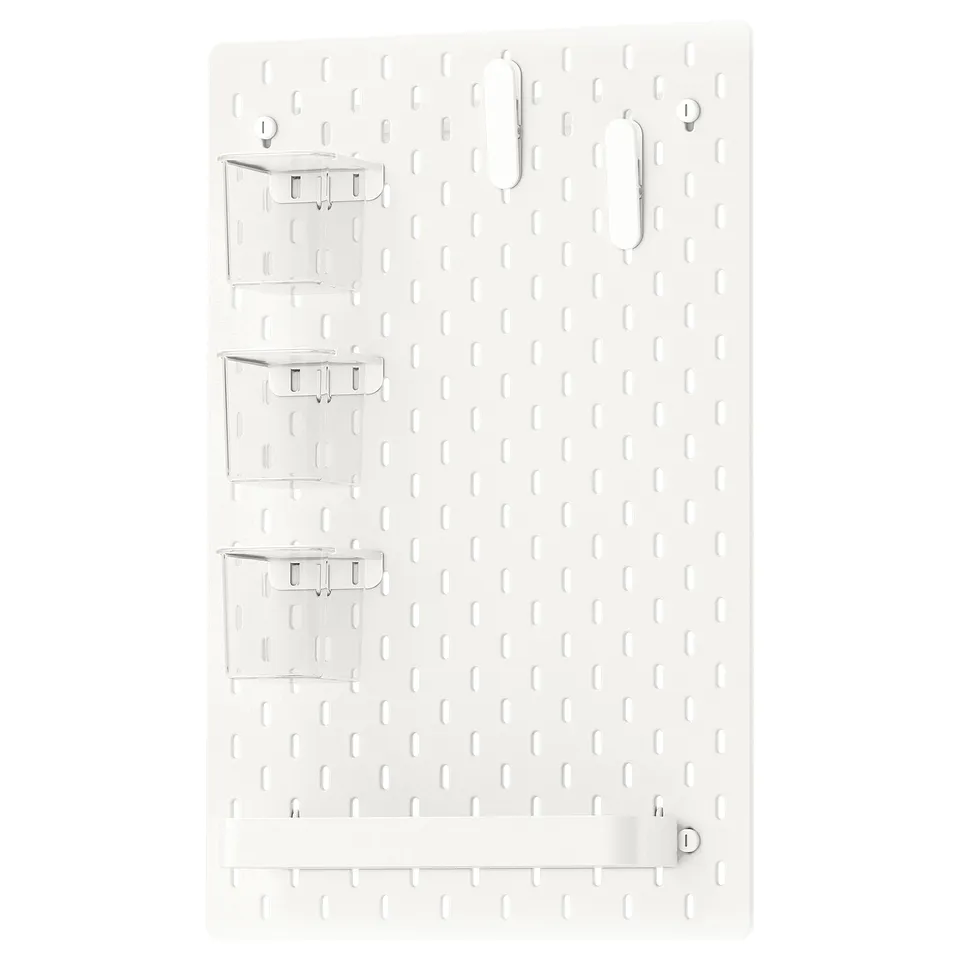 SKÅDIS white organising board, featuring clear acrylic containers, metal hooks, and a shelf, mounted on a grid background. Easy to move and customise.
