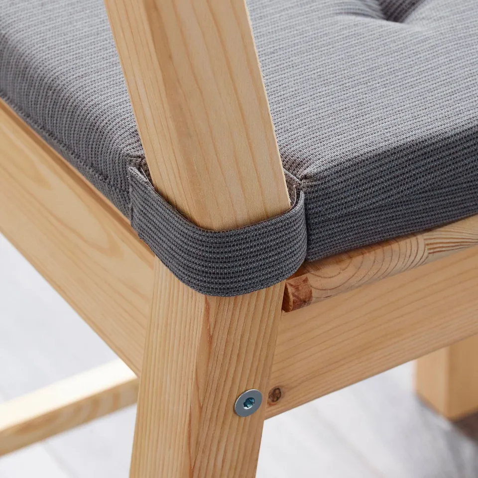 Close-up of JUSTINA chair pad, secured with velcro, showing soft foam comfort.