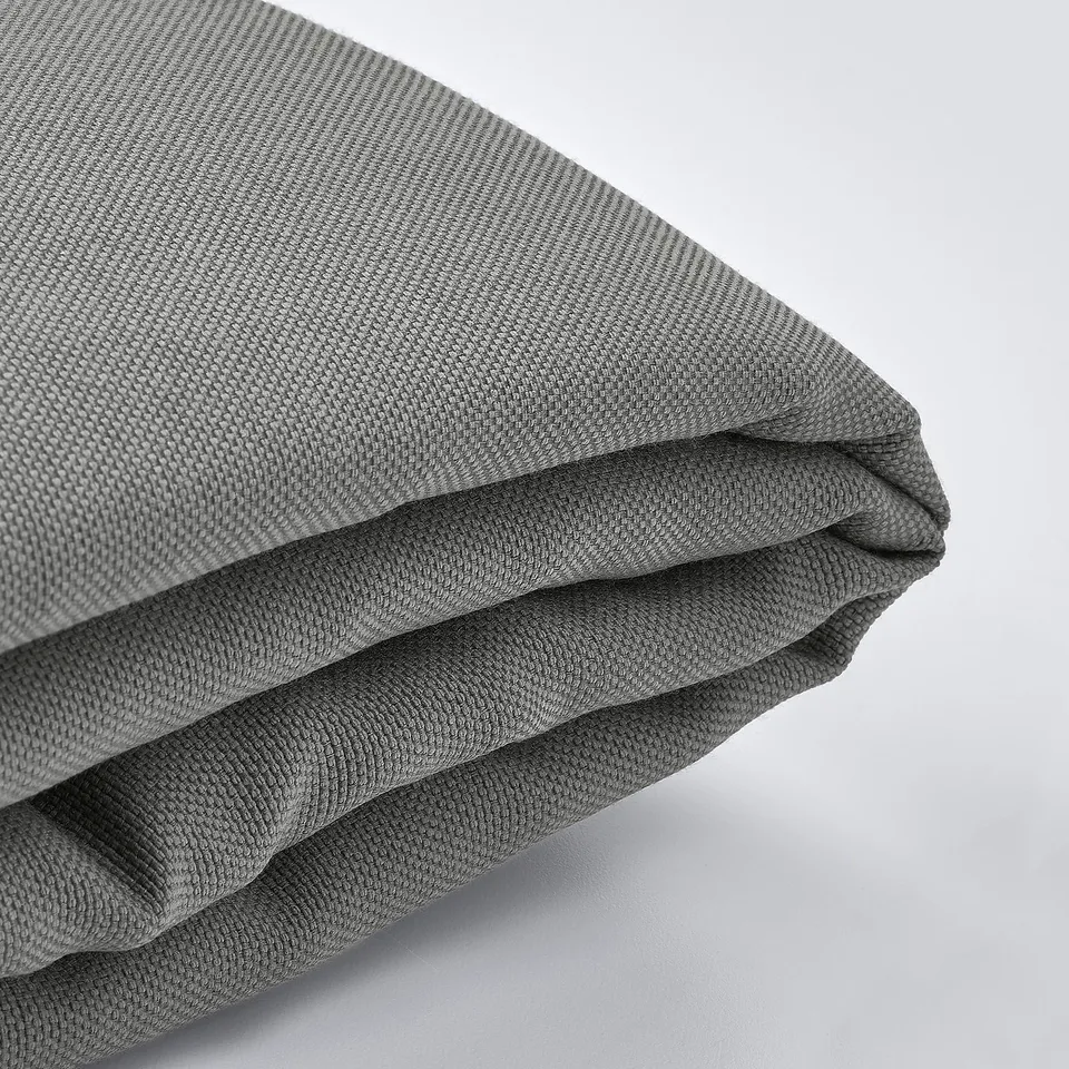 A close-up of a folded grey fabric, showcasing its smooth texture and stitching detail.