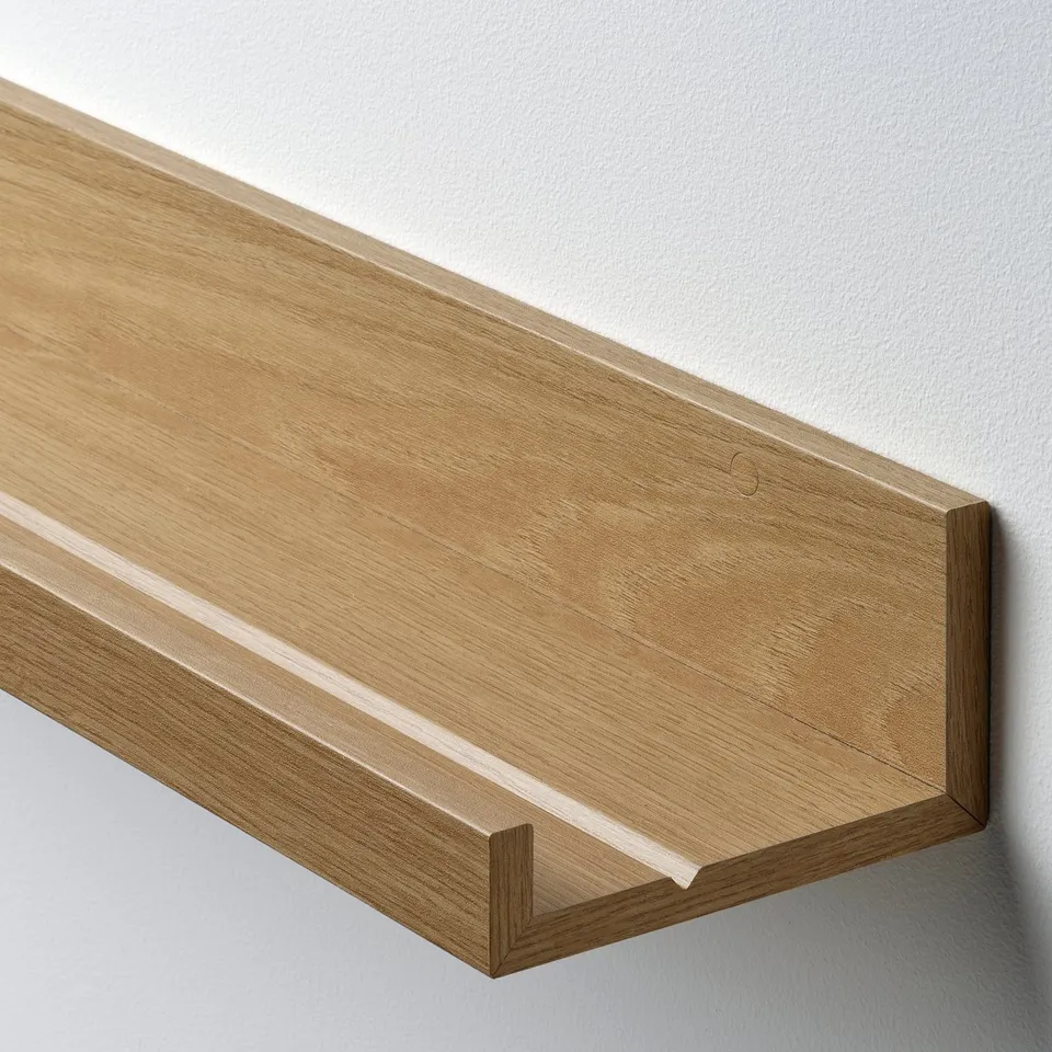 Light wood shelf mounted on a wall with a slim, sturdy design. It fits picture frames, enhancing home decor.