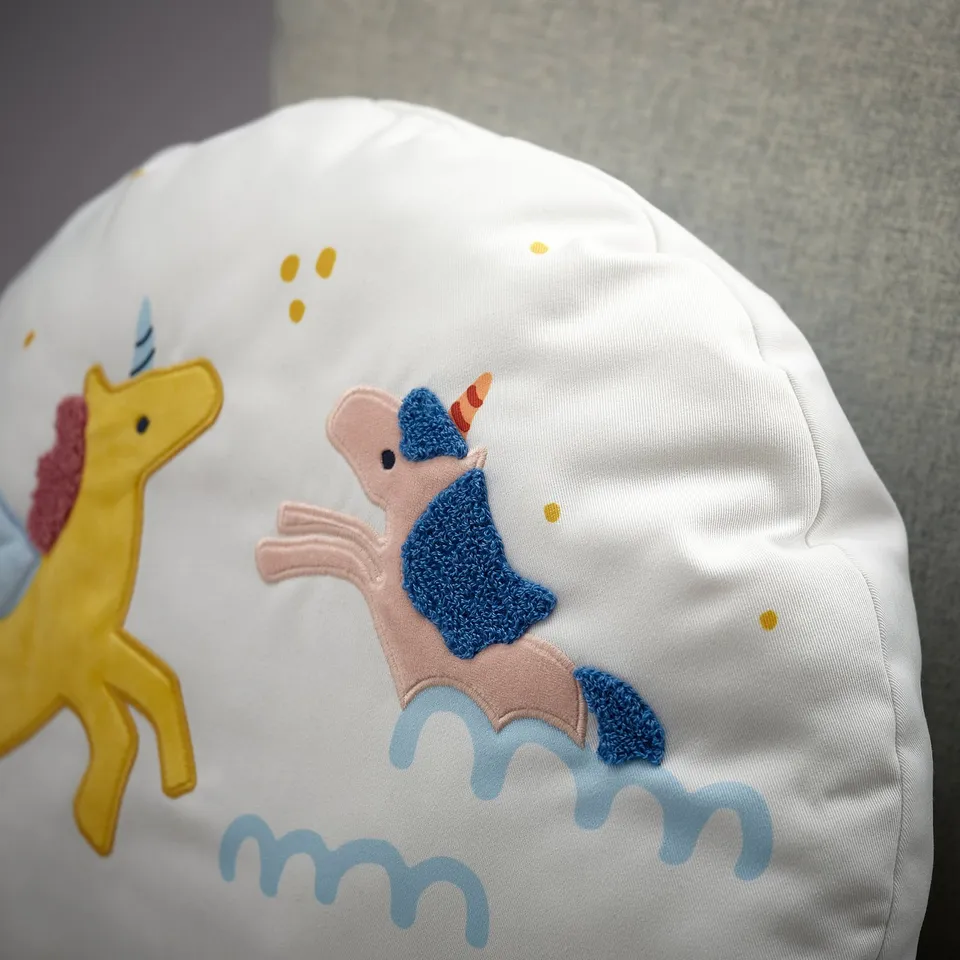 Whimsical kids pillow showcasing a cute unicorn appliqué and subtle rainbow print on recycled polyester.