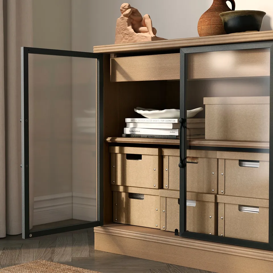 Modern wooden cabinet with open door showing storage boxes for papers, notebooks, and accessories.