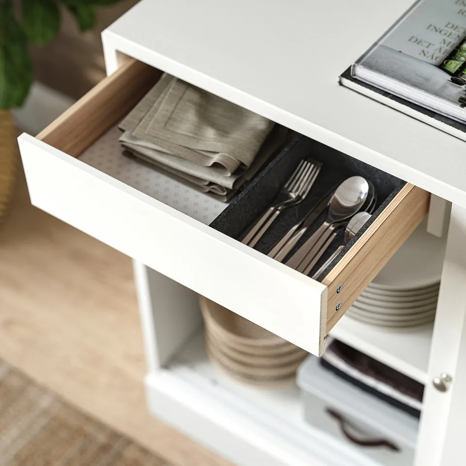 Open white HAVSTA drawer shows folded napkins and cutlery.