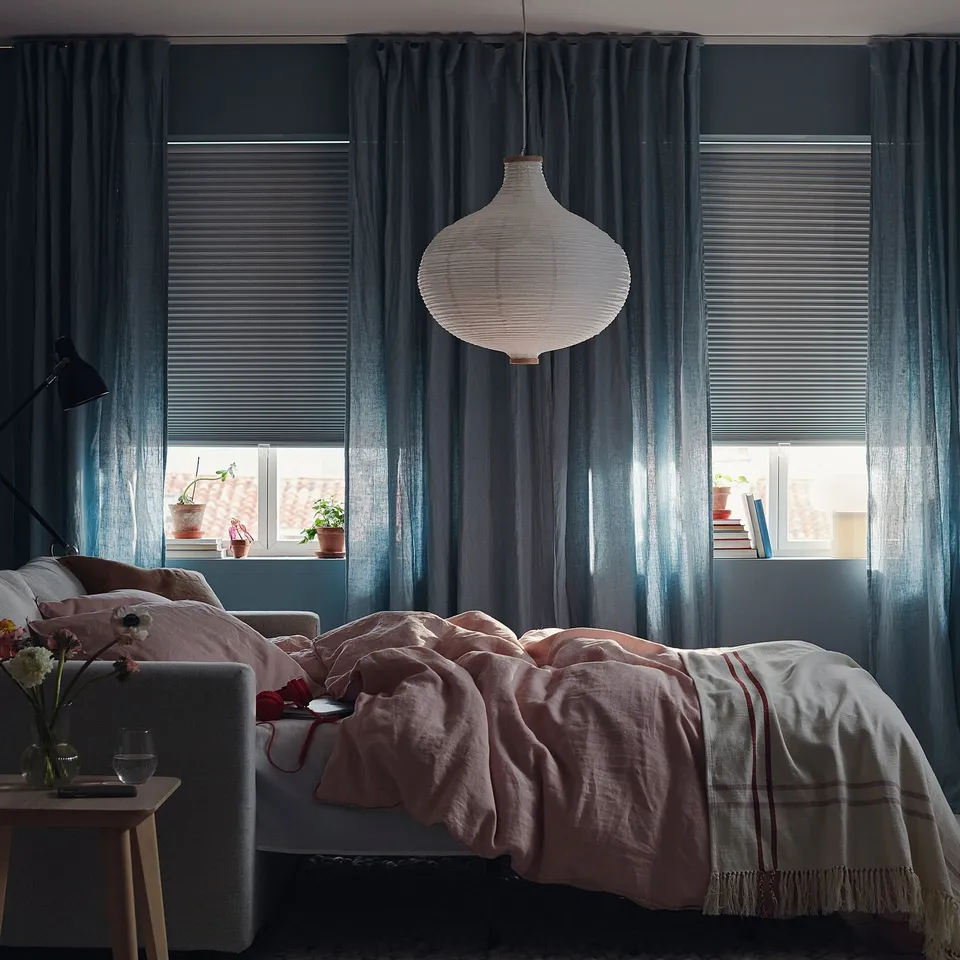 Bedroom with large windows featuring TRIPPEVALS block-out blinds for light control, and a hanging lamp above the bed.