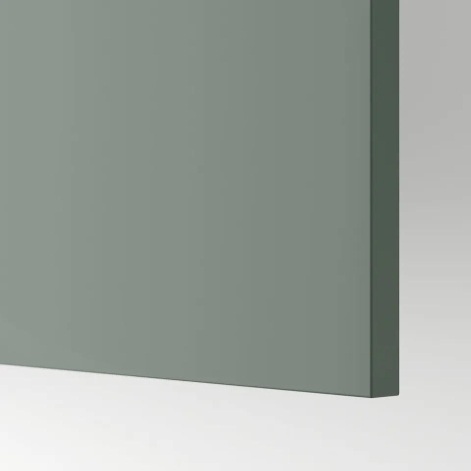 A close-up of a smooth, grey-green kitchen cabinet front, showcasing its matt finish and uniform texture.