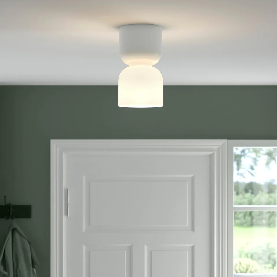 A modern ceiling lamp emitting soft light, providing general and directional illumination.