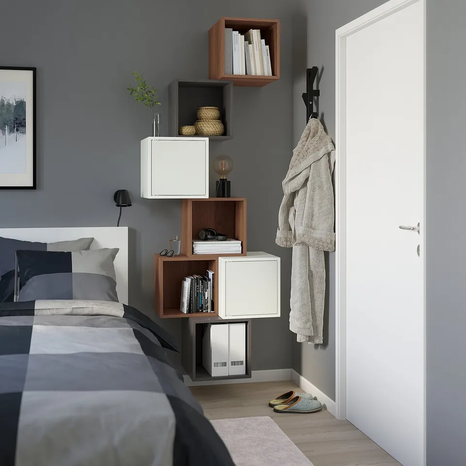 EKET modular storage in bedroom, mix of white/wood cubes, gray/white bedding, organised.