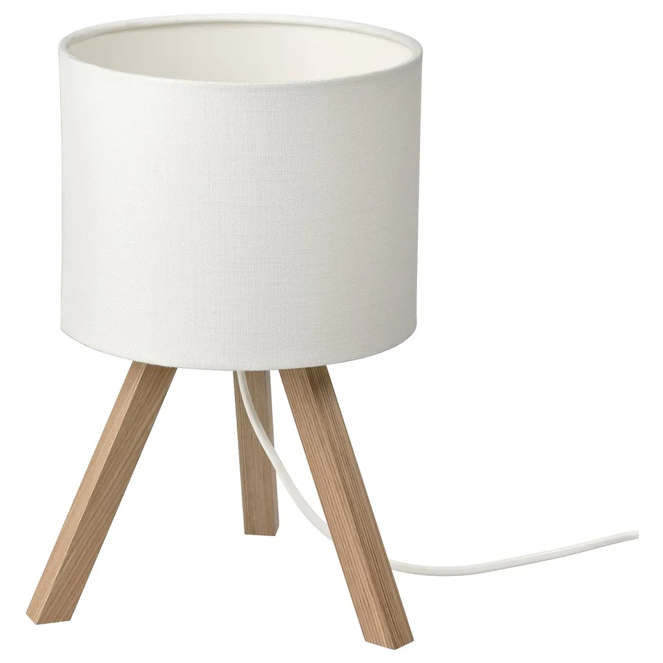 A STORSEGEL lamp with a white shade and wooden tripod legs. The design is modern and minimalist.