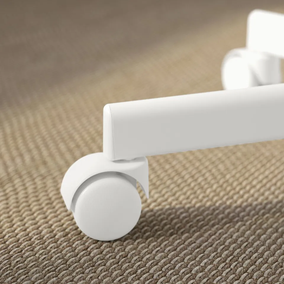 White office chair caster close-up, one wheel slightly off the ground.