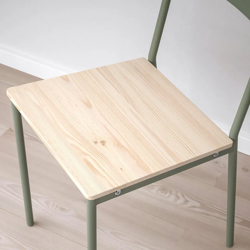 Modern chair with light wood seat and green metal legs, designed for comfort and durability.