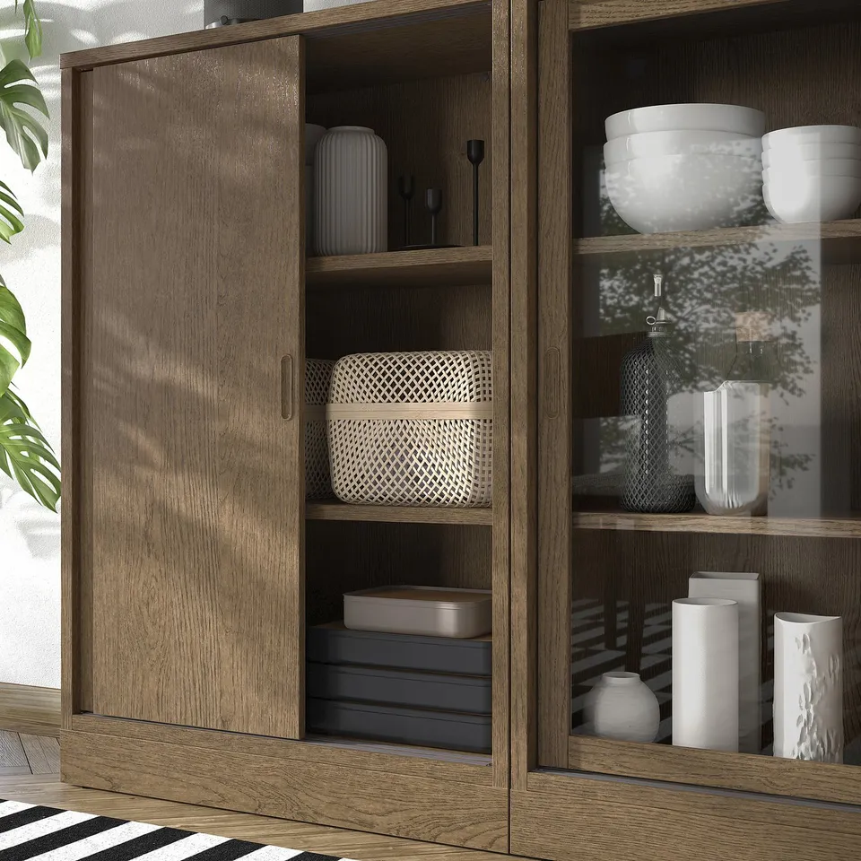 Wooden cabinet with sliding doors, adjustable shelves, and decorative items.