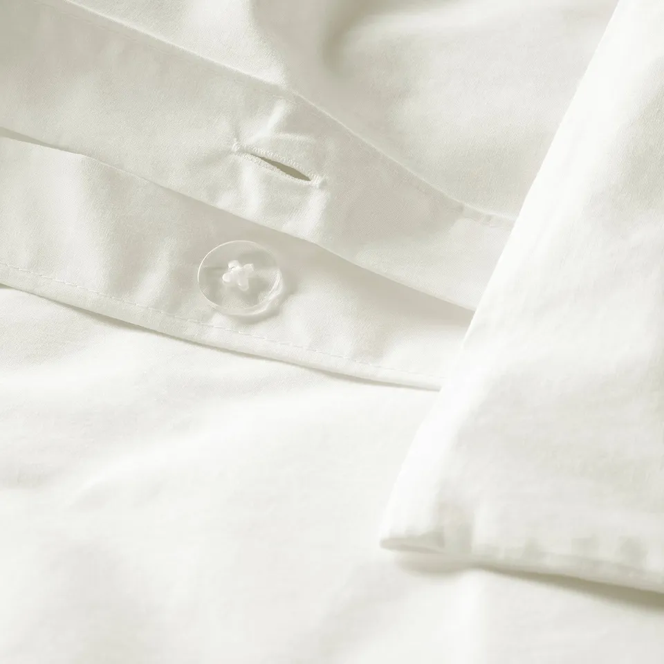 Close-up of crisp white duvet cover with one button visible, showcasing its neat design and high-quality fabric.