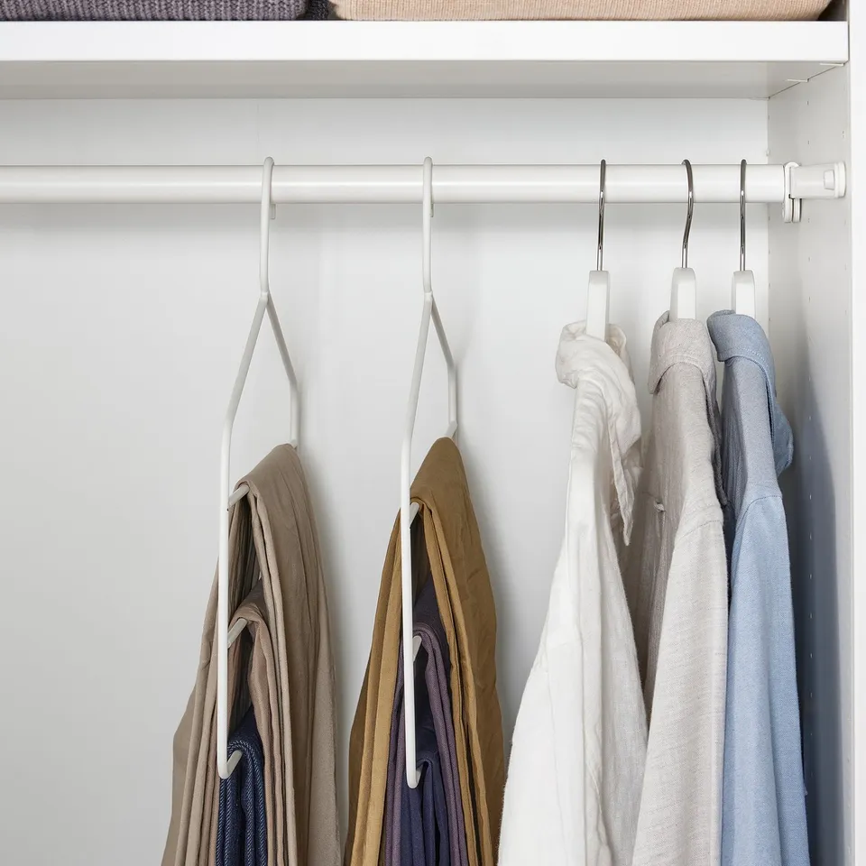 Closet with GÅRDSMÄSTARE hangers organising multiple trousers and skirts efficiently, saving space.