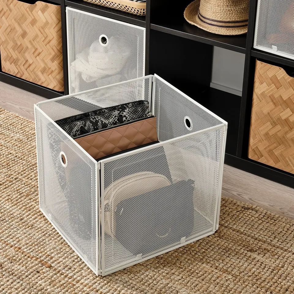 White metal storage box with mesh net, open and showing interior. Part of DRÖNJÖNS series, fits kallax shelving, easy to pull out.