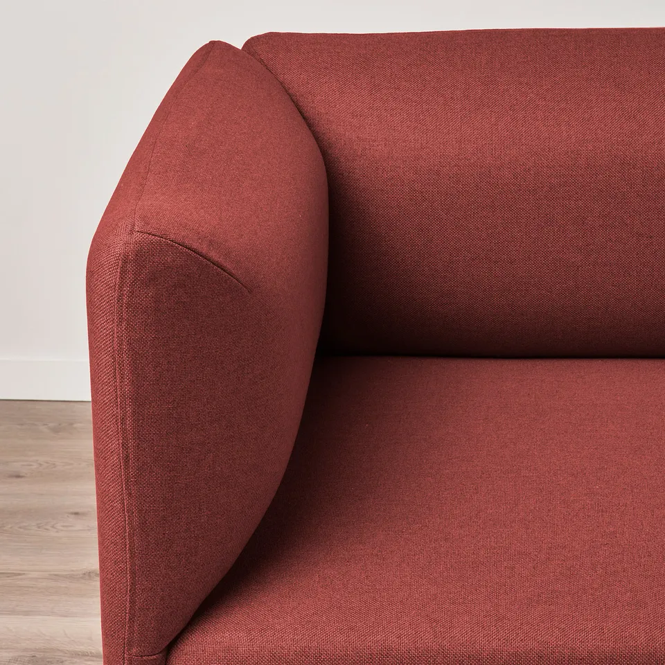 Close-up of LILLEHEM sofas armrest: thick, red fabric, cosy and sturdy.