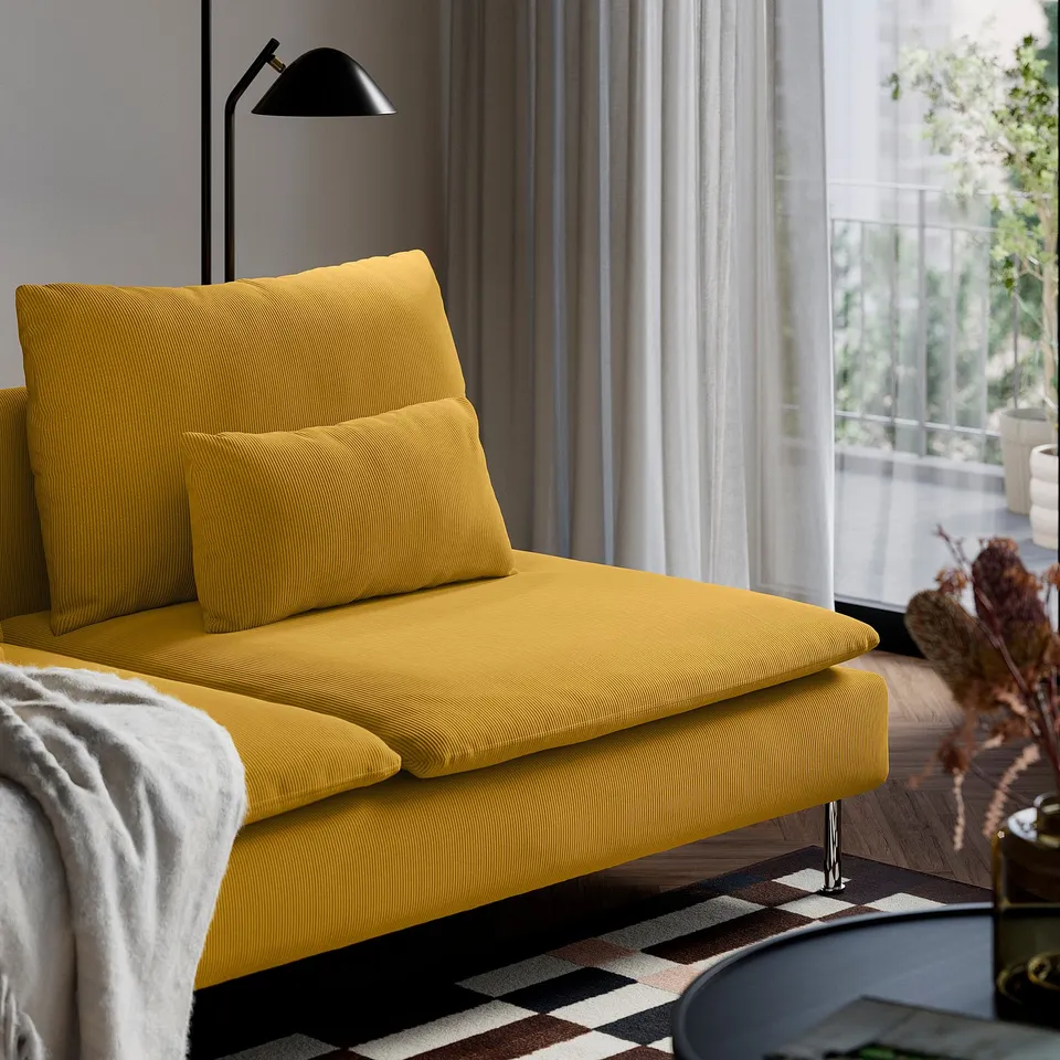 A modern yellow sofa with cushions, near a window.