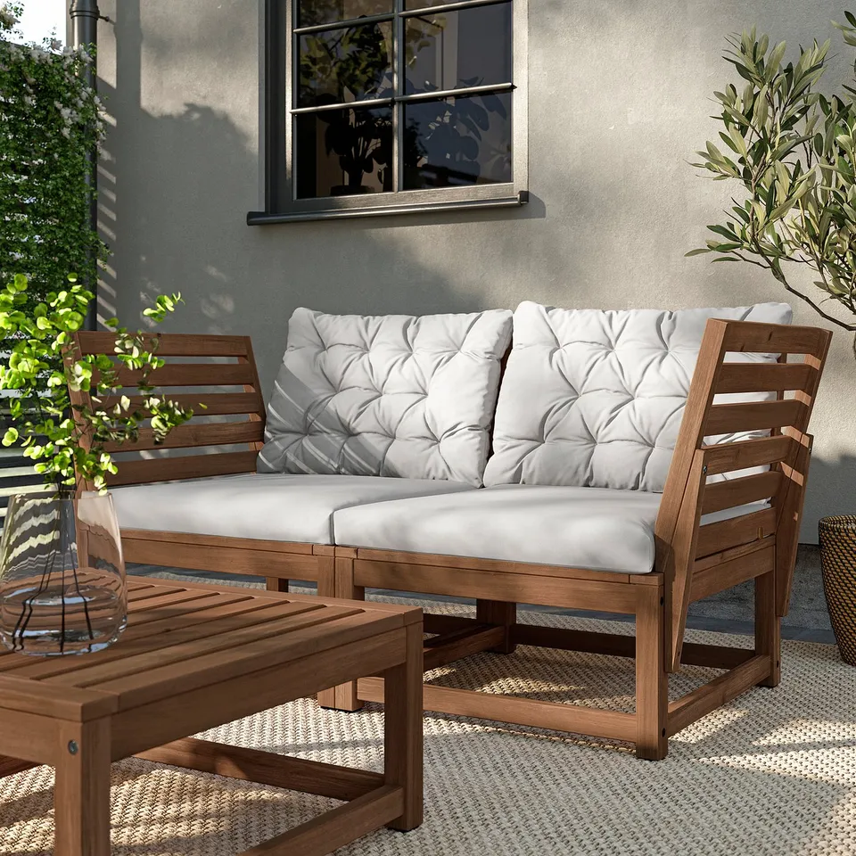 Outdoor patio set - NÄMMARÖ: wooden sofa with white cushions, acacia wood, slatted design.