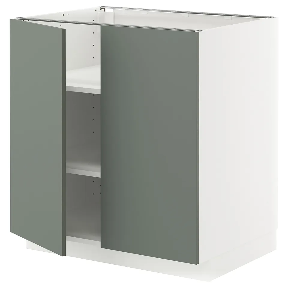 A modern white and green kitchen cabinet with adjustable shelves from the METOD system.