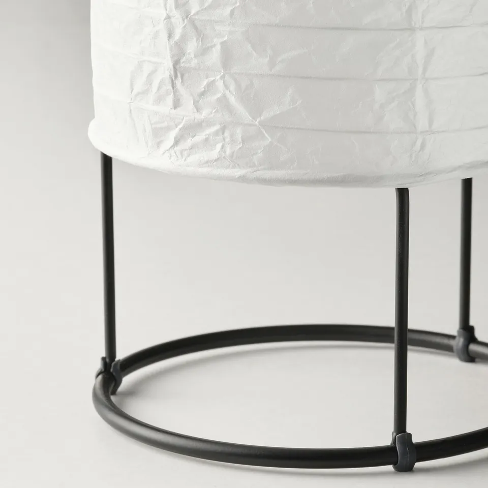Cylindrical lamp with textured white rice paper shade on black metal stand.