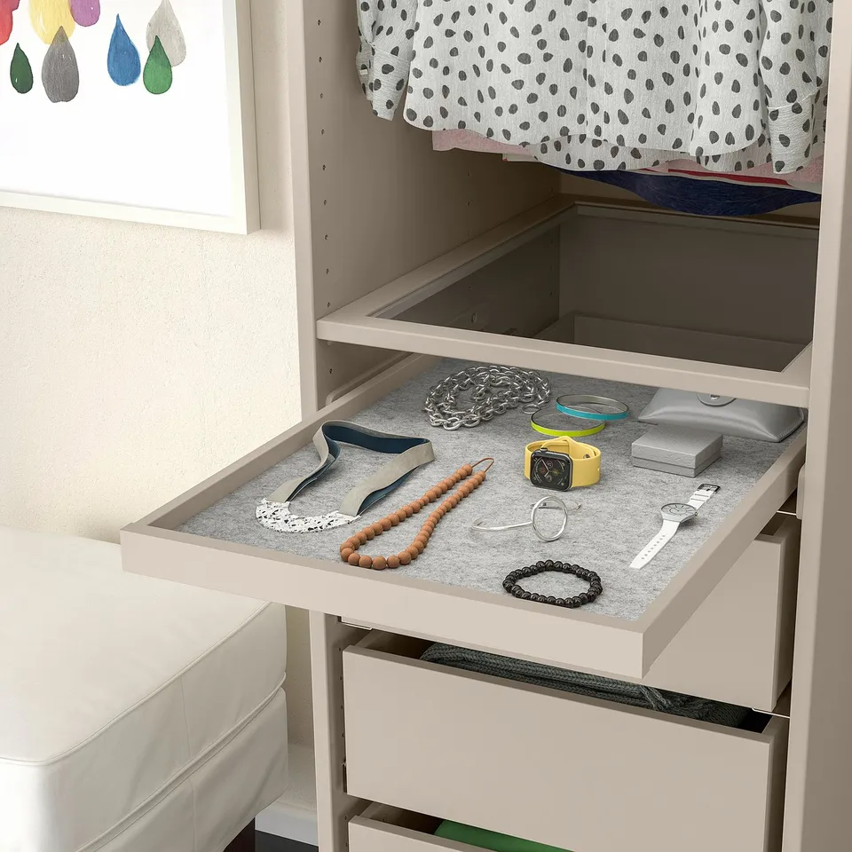 Open drawer organiser displaying accessories, including jewellery and watches, on a soft felt liner.