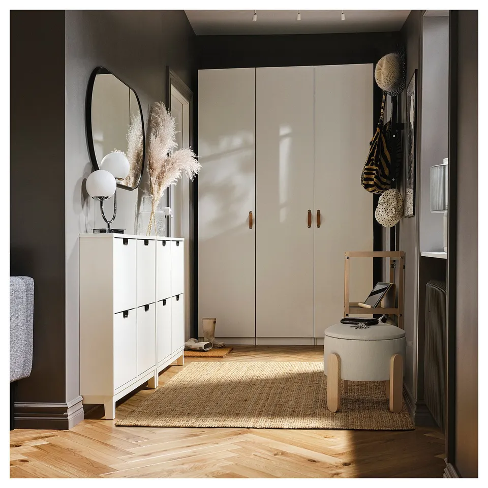 Modern entryway featuring a white FÖRLUNDA pouffe with a light grey upholstered seat, positioned on wooden flooring.
