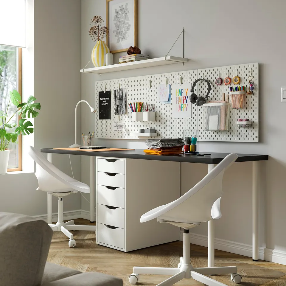 Home office with LAGKAPTEN desk, drawers, pegboard, 2 chairs, plant.