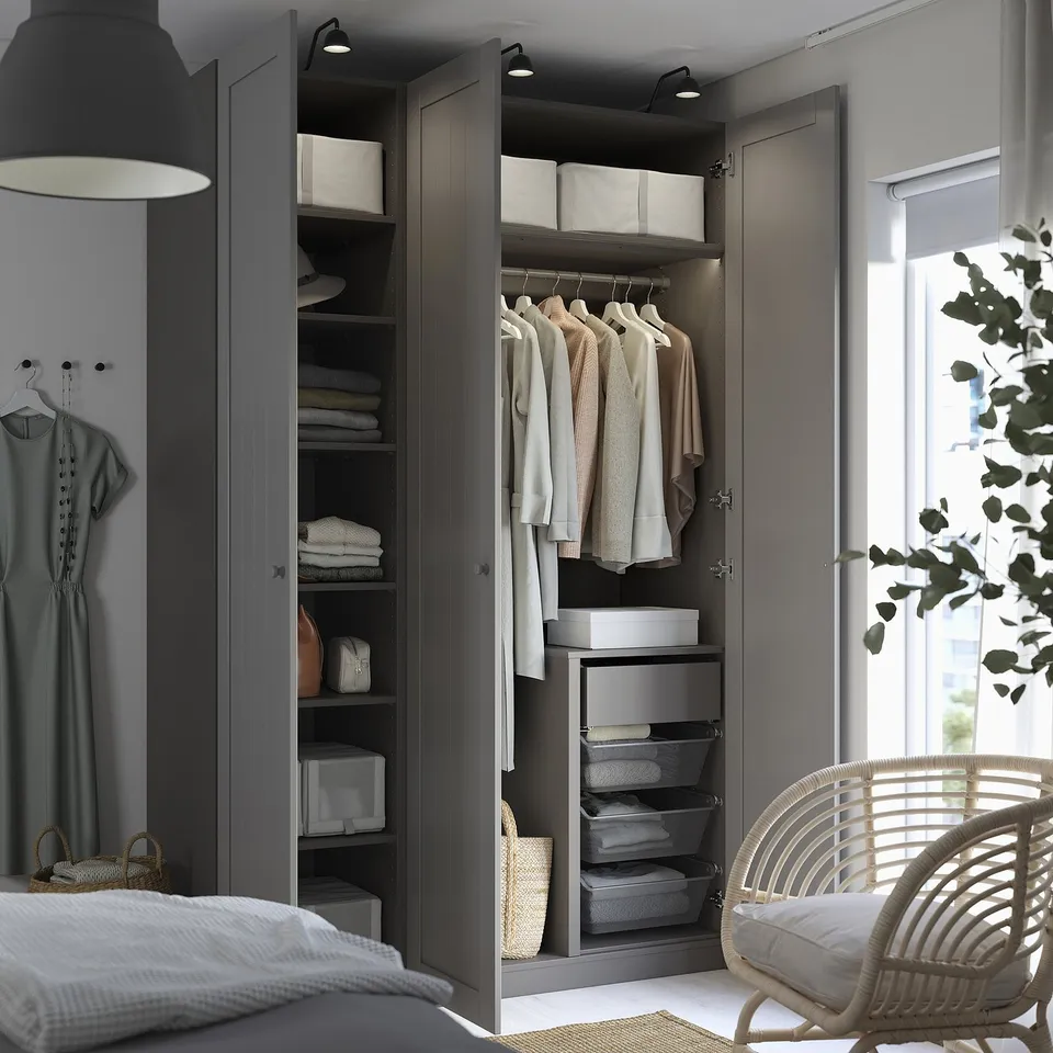 Modern wardrobe open showing clothes, shelves, and storage boxes, well-organized with foldable items.