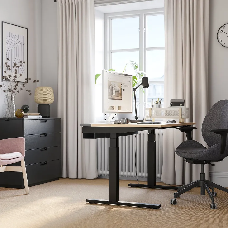 Modern home office with MITTZON black sit/stand desk, adjustable chair, and computer.
